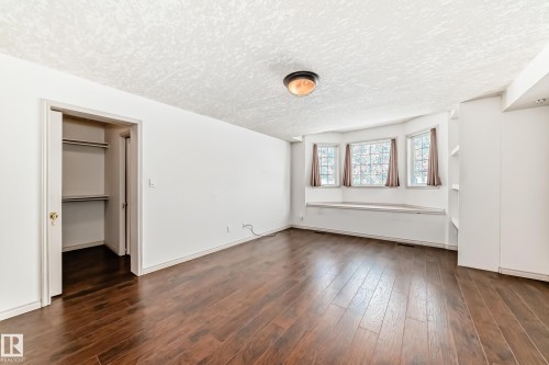 This room features rich hardwood flooring, a closet with shelving, and a bay window with an integrated bench seat - 10631 181 Avenue, Edmonton, AB - Indoor
