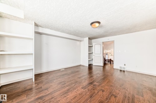 This room features rich wood flooring, white walls, and built-in shelving - 10631 181 Avenue, Edmonton, AB - Indoor Photo Showing Other Room