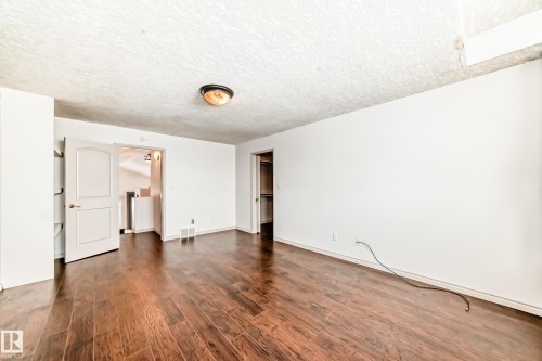 This room features rich hardwood flooring and white painted walls, creating a bright and inviting atmosphere - 10631 181 Avenue, Edmonton, AB - Indoor Photo Showing Other Room