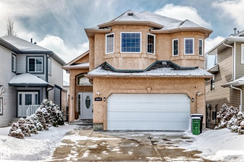 The property features a stucco exterior, an attached garage, and a welcoming front entrance with an oval glass insert in the door - 10631 181 Avenue, Edmonton, AB - Outdoor With Facade