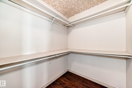 The property features a closet with shelving, hanging rods, and dark wood flooring - 10631 181 Avenue, Edmonton, AB - Indoor With Storage