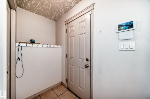 Entryway featuring a paneled door, tile flooring, and wall-mounted light switches - 10631 181 Avenue, Edmonton, AB - Indoor Photo Showing Other Room