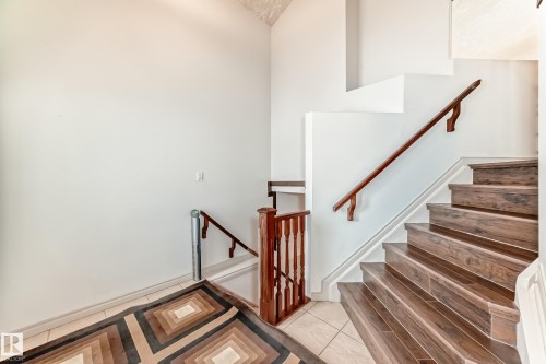 The property features a staircase with rich, dark wood treads and a complementary wooden handrail - 10631 181 Avenue, Edmonton, AB - Indoor Photo Showing Other Room