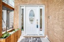 The property features a white front door with an oval glass insert and decorative side panels, set against a textured exterior wall - 10631 181 Avenue, Edmonton, AB  - Outdoor With Exterior 