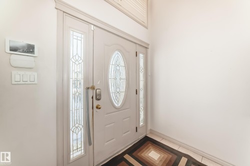 The entry features a white door with an oval-shaped glass insert, flanked by two sidelight windows with decorative glass - 10631 181 Avenue, Edmonton, AB - Indoor Photo Showing Other Room