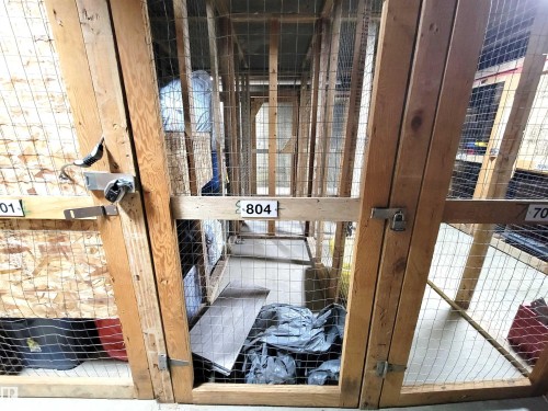Dedicated storage locker with a locking mechanism, featuring wood framing and wire mesh construction - 804 9028 Jasper Avenue, Edmonton, AB - Indoor Photo Showing Other Room