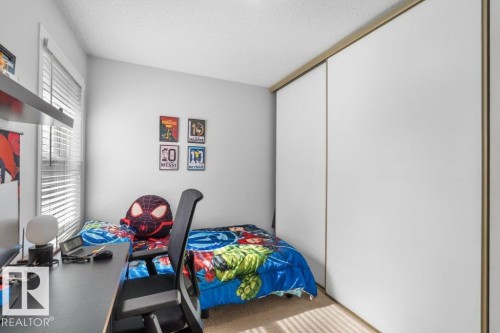 This room features a window with blinds, a built-in shelf, and a large sliding door closet - 638 Saddleback Road, Edmonton, AB - Indoor Photo Showing Bedroom