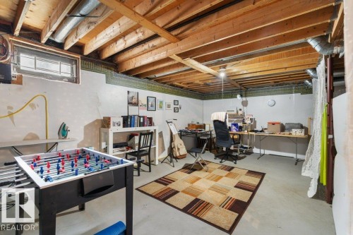Spacious room with a concrete floor, exposed wood ceiling beams, and a window providing natural light - 638 Saddleback Road, Edmonton, AB - Indoor Photo Showing Basement