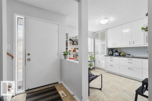 The property features a bright entrance with a white door and a full-length sidelight, leading into a space with tiled flooring - 638 Saddleback Road, Edmonton, AB - Indoor Photo Showing Other Room