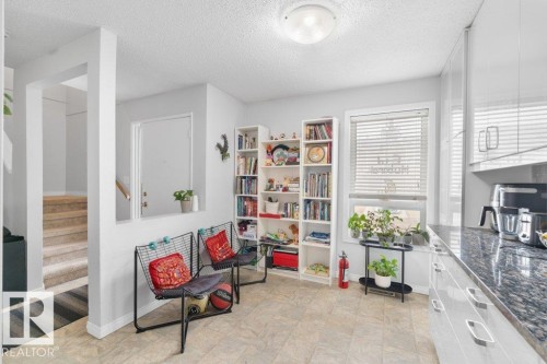 The property features a bright kitchen area with granite countertops and white cabinetry, complemented by a large window with blinds - 638 Saddleback Road, Edmonton, AB - Indoor