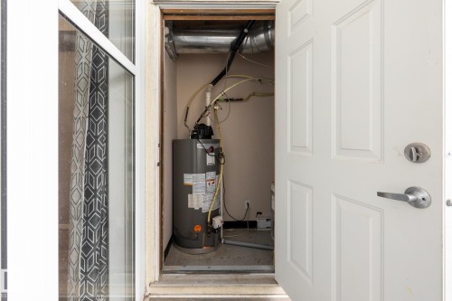 Utility closet with a water heater and visible ductwork - 210 10147 112 Street, Edmonton, AB - 
