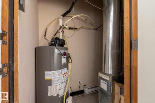 This utility space features a water heater and a furnace - 210 10147 112 Street, Edmonton, AB - Indoor Photo Showing Basement