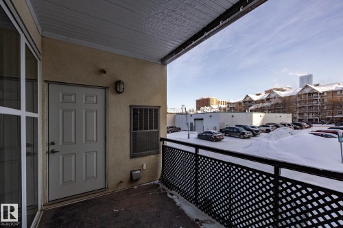 Private balcony with an exterior door and a window, featuring a latticework railing - 210 10147 112 Street, Edmonton, AB - Outdoor With Exterior