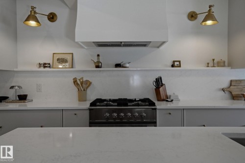 Kitchen featuring light-colored countertops, a range with a hood, and open shelving - 9228 100 Avenue, Edmonton, AB - Indoor Photo Showing Kitchen