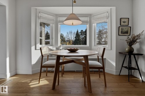 This space features hardwood floors and a bay window with a built-in bench seat - 9228 100 Avenue, Edmonton, AB - Indoor Photo Showing Dining Room