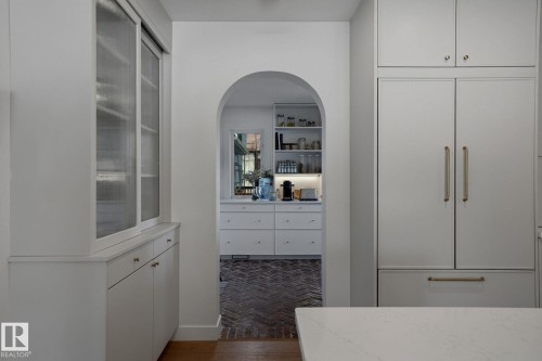 Kitchen featuring integrated appliances, white cabinetry with gold hardware, and a white countertop - 9228 100 Avenue, Edmonton, AB - Indoor Photo Showing Other Room