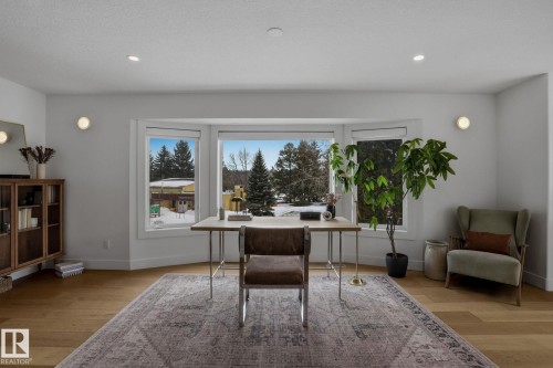 This room features hardwood floors, recessed lighting, and a bay window providing views of the outdoors - 9228 100 Avenue, Edmonton, AB - Indoor Photo Showing Other Room