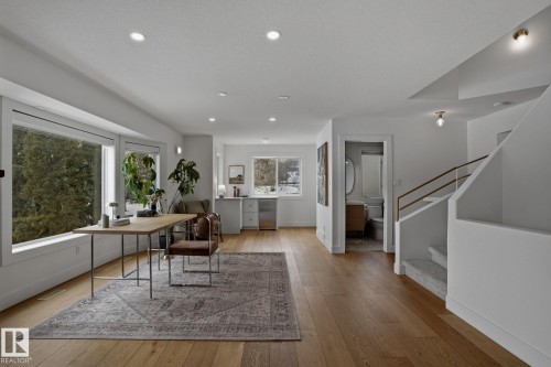 This bright living space features hardwood floors, recessed lighting, and large windows that provide abundant natural light - 9228 100 Avenue, Edmonton, AB - Indoor