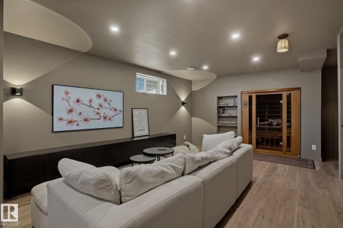 The property features a recreational room with recessed lighting, wall sconces, and wood-style flooring - 9228 100 Avenue, Edmonton, AB - Indoor