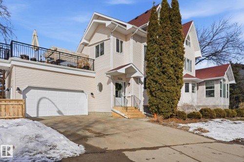 The property features light-colored siding, a red roof, and a two-car garage with a paved driveway - 9228 100 Avenue, Edmonton, AB - Outdoor With Facade