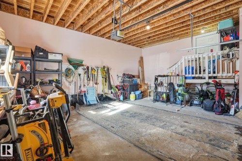 The property features an attached garage with exposed wooden ceiling beams and a partial stair structure - 9228 100 Avenue, Edmonton, AB - Indoor Photo Showing Garage