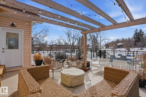The property features an expansive outdoor patio with a wooden pergola, equipped with string lighting - 9228 100 Avenue, Edmonton, AB - Outdoor With Deck Patio Veranda With Exterior