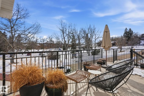 The property features an outdoor patio area with a black metal railing, offering views of a snowy landscape and bare trees - 9228 100 Avenue, Edmonton, AB - Outdoor With Deck Patio Veranda