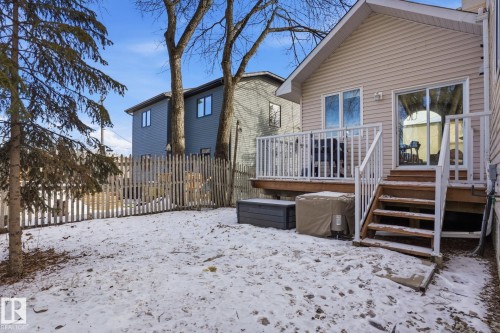 The property features a private backyard with a wooden fence and mature trees - 9228 100 Avenue, Edmonton, AB - Outdoor With Deck Patio Veranda