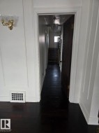 Corridor with dark wood finished floors, stairway, and a decorative wall - 