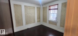 Empty room featuring baseboards and dark wood-style floors - 