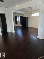 Unfurnished dining area with a decorative wall, dark wood-style floors, a textured ceiling, and a chandelier - 