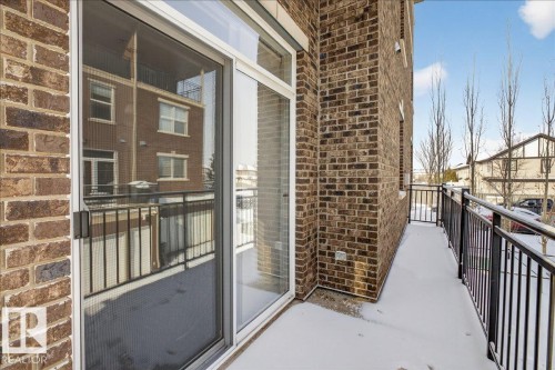 The property features a balcony with a black metal railing, accessible via a sliding glass door - 2105 Casselman Link Link, Edmonton, AB - Outdoor With Balcony With Exterior