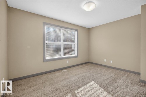 The room features neutral-toned walls, a window with blinds, and carpeted flooring - 2105 Casselman Link Link, Edmonton, AB - Indoor Photo Showing Other Room