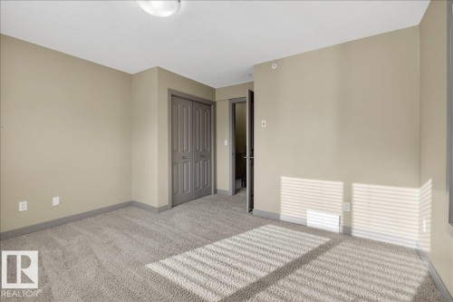Spacious room featuring neutral carpeting, light beige walls, and a ceiling light fixture - 2105 Casselman Link Link, Edmonton, AB - Indoor Photo Showing Other Room