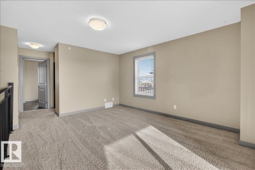 Bright room featuring a window with blinds, neutral-toned walls, and plush carpeting - 2105 Casselman Link Link, Edmonton, AB - Indoor Photo Showing Other Room