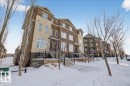 The property features a multi-story exterior with a combination of brick and stone cladding, multiple windows, and a paved walkway leading to the entrance - 2105 Casselman Link Link, Edmonton, AB  - Outdoor With Facade 