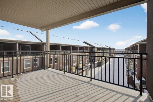 The property features a covered balcony with black metal railings and a concrete floor - 2105 Casselman Link Link, Edmonton, AB - Outdoor With Balcony With Exterior