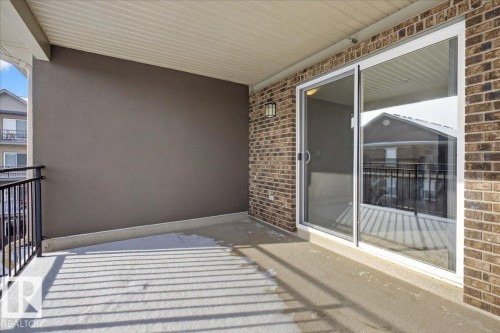 The property features a private balcony with brick exterior walls and a sliding glass door - 2105 Casselman Link Link, Edmonton, AB - Outdoor With Balcony With Exterior