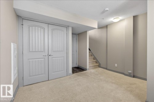 The property features light-colored carpet, painted walls, and a light fixture on the ceiling - 2105 Casselman Link Link, Edmonton, AB - Indoor Photo Showing Other Room