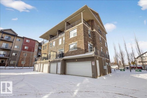 The property features a multi-story exterior with a brick facade and balconies - 2105 Casselman Link Link, Edmonton, AB - Outdoor With Balcony