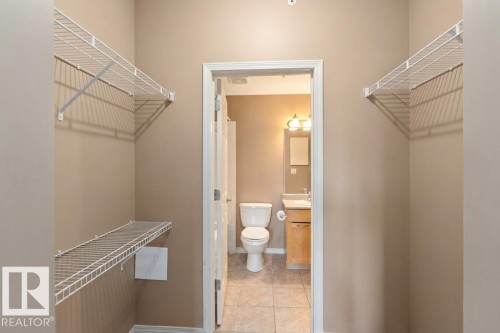 This space features wire shelving for storage, with a doorway leading to a bathroom - 1-204 4245 139 Avenue, Edmonton, AB - Indoor