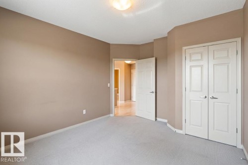 Neutral tone walls, light-colored carpet, and white trim throughout - 1-204 4245 139 Avenue, Edmonton, AB - Indoor Photo Showing Other Room