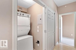 Dedicated laundry area featuring a white stacked washer and dryer unit - 