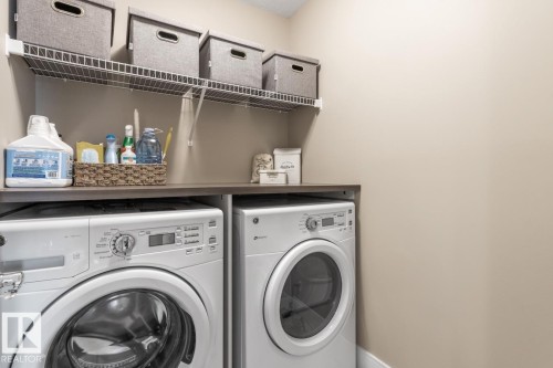 Located on the Second Floor this Laundry Room Features Counter Space, Storage, and a Floor Drain - 7432 Colonel Mewburn Road, Edmonton, AB - Indoor Photo Showing Laundry Room