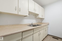 Kitchen with light countertops, white cabinetry, and light tile patterned floors - 