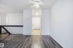 Unfurnished room with dark wood-style flooring and ceiling fan - 