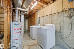 Laundry area featuring unfinished concrete flooring, water heater, and independent washer and dryer - 