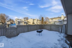 Yard layered in snow with a residential view, a fenced backyard, and a gate - 