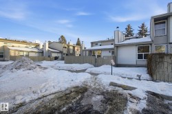 Snow covered back of property with a residential view and a chimney - 