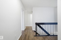 Corridor featuring an upstairs landing and dark wood-style flooring - 